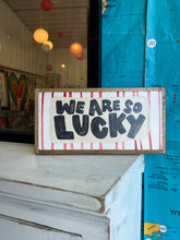 Load image into Gallery viewer, 7x13 NEW! “We are so lucky” Hand-Painted Sign