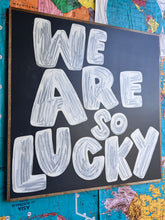 Load image into Gallery viewer, 37x37 RESTOCKED “We Are So Lucky” Hand-Painted Sign

